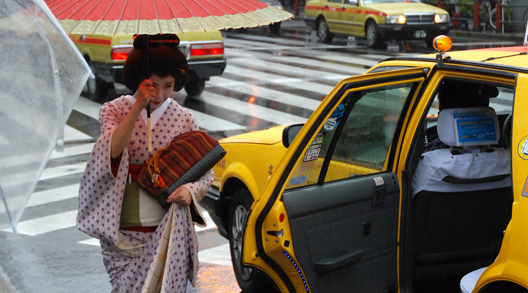 Geisha in Tokyo die in een taxi stapt