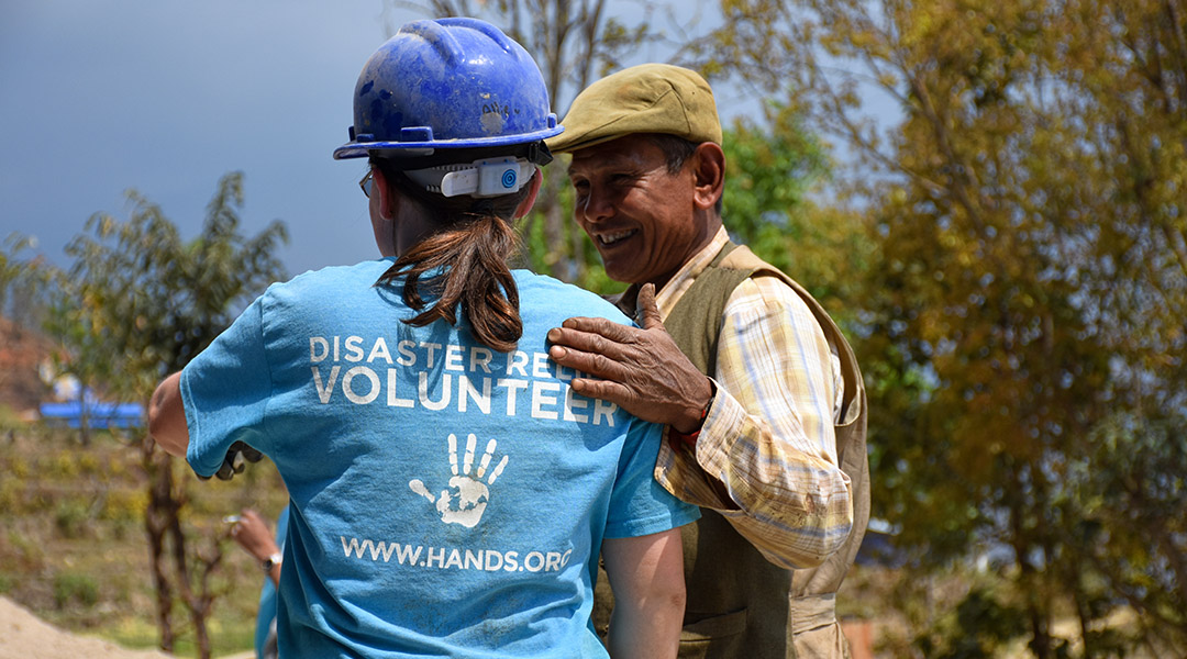 Een vrijwilliger samen met één van de ondernemers in Nepal voor All Hands Volunteers